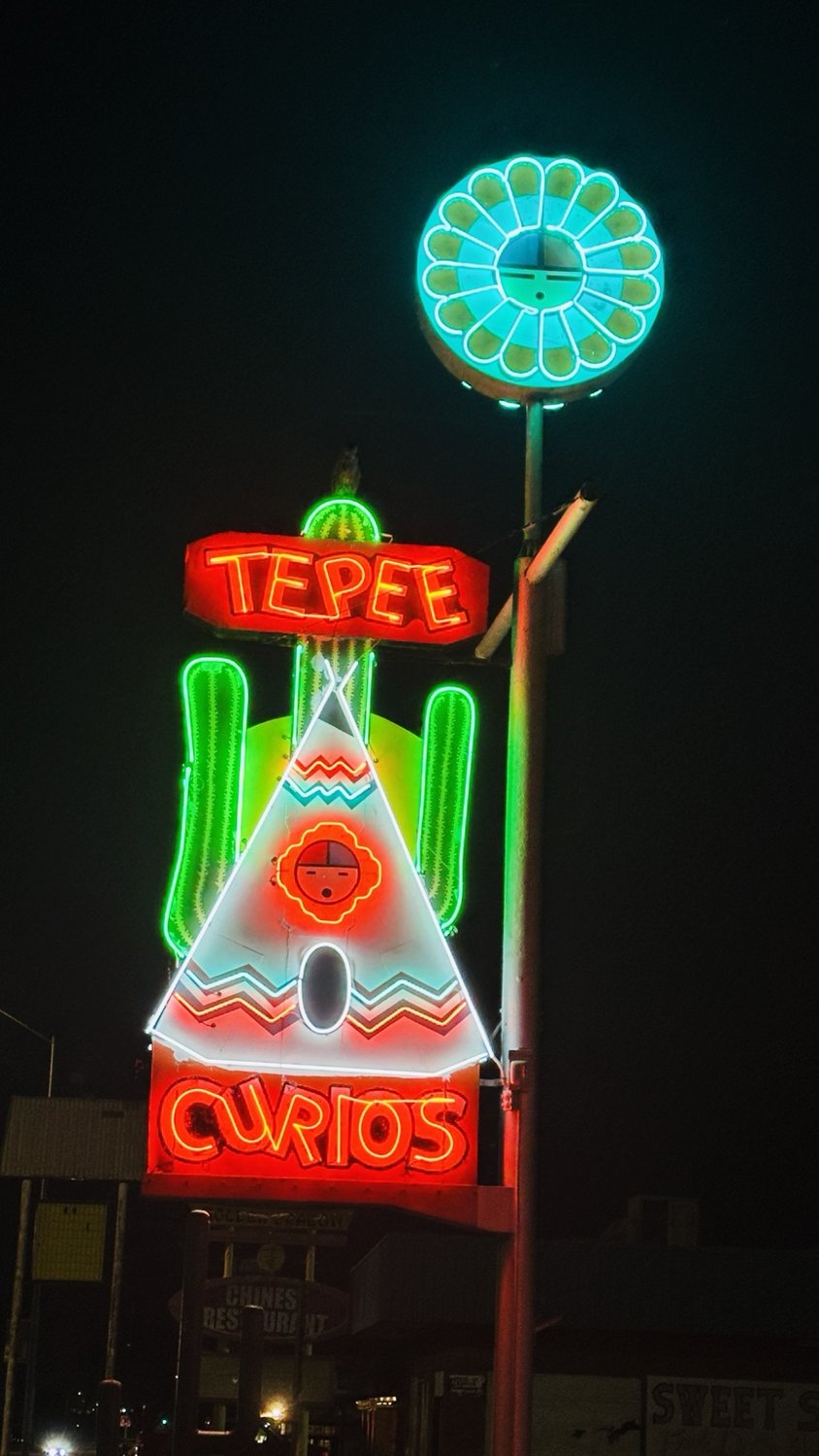 Colorful Teepee Curios neon sign after dark